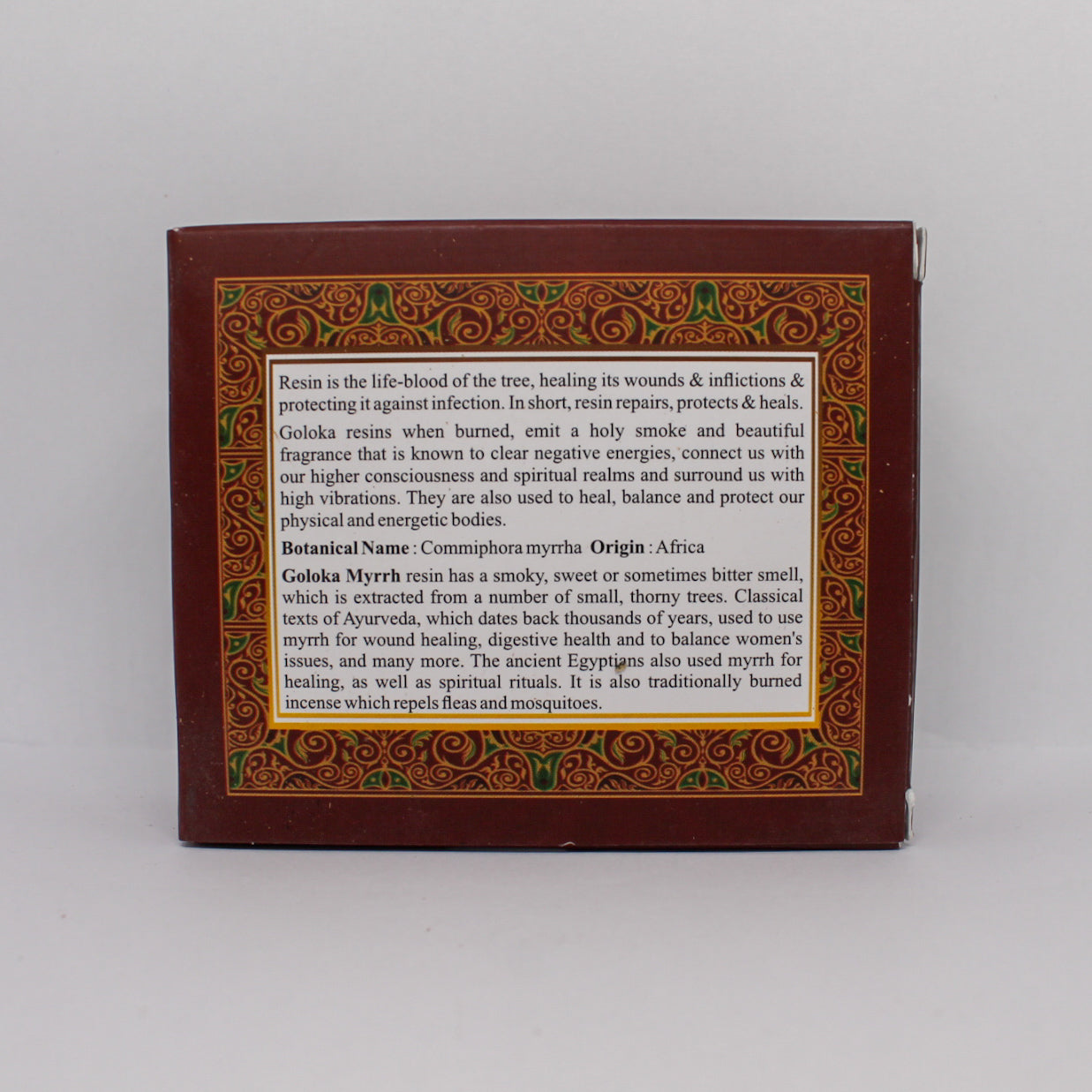 Tylna strona brązowego pudełka Goloka Myrrh Resin Incense z opisem właściwości i zastosowań żywicy mirry. Tekst umieszczony w ozdobnej ramce na tle złotego wzoru.