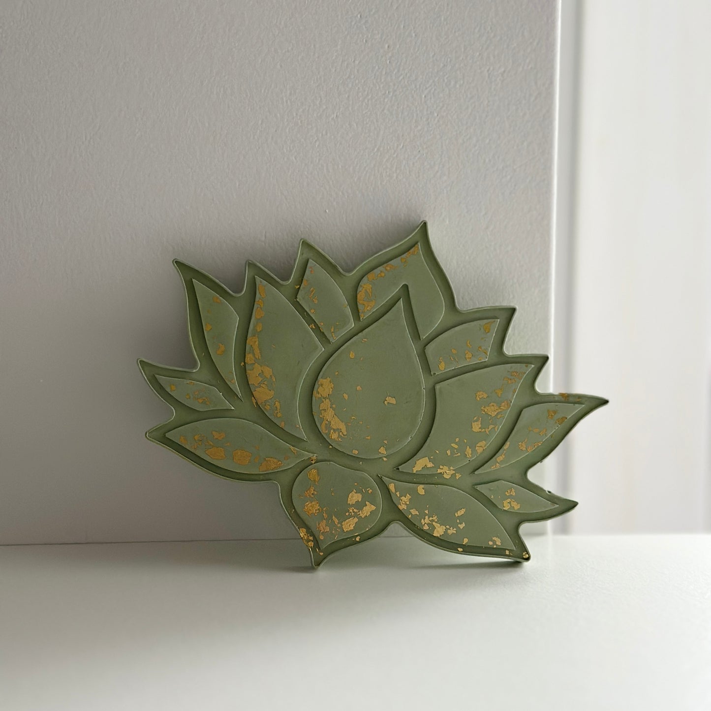 Stojak w kształcie lotosu w oliwkowym kolorze z ozdobnymi złotymi akcentami, podkreślającymi krawędzie płatków.