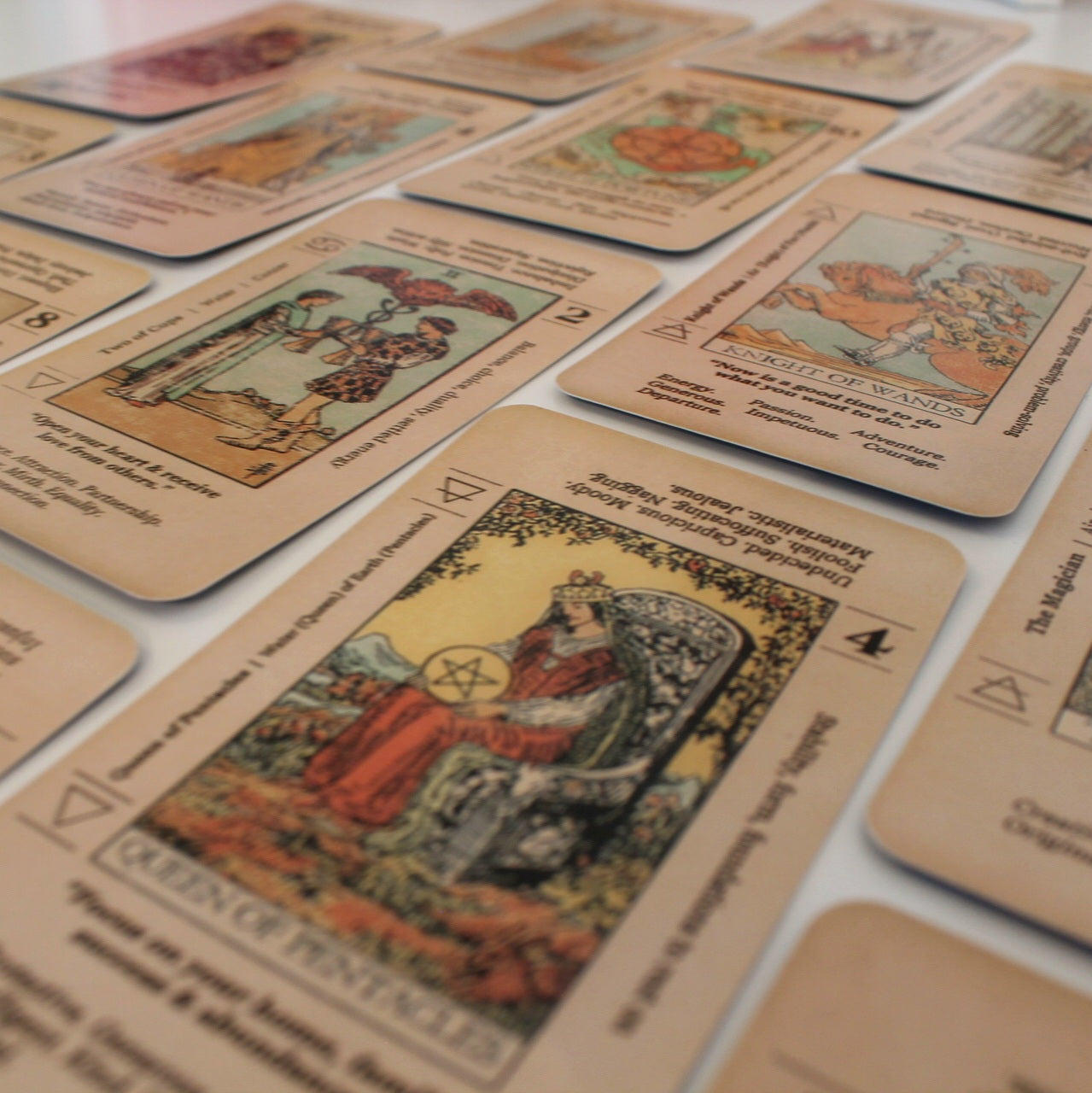 Zdjęcie przedstawia rozłożone karty tarota z talia "Meaning Tarot". Każda karta ma klasyczną grafikę tarota oraz słowa kluczowe wzdłuż krawędzi karty, odnoszące się do jej znaczenia i zodiakalnych połączeń.