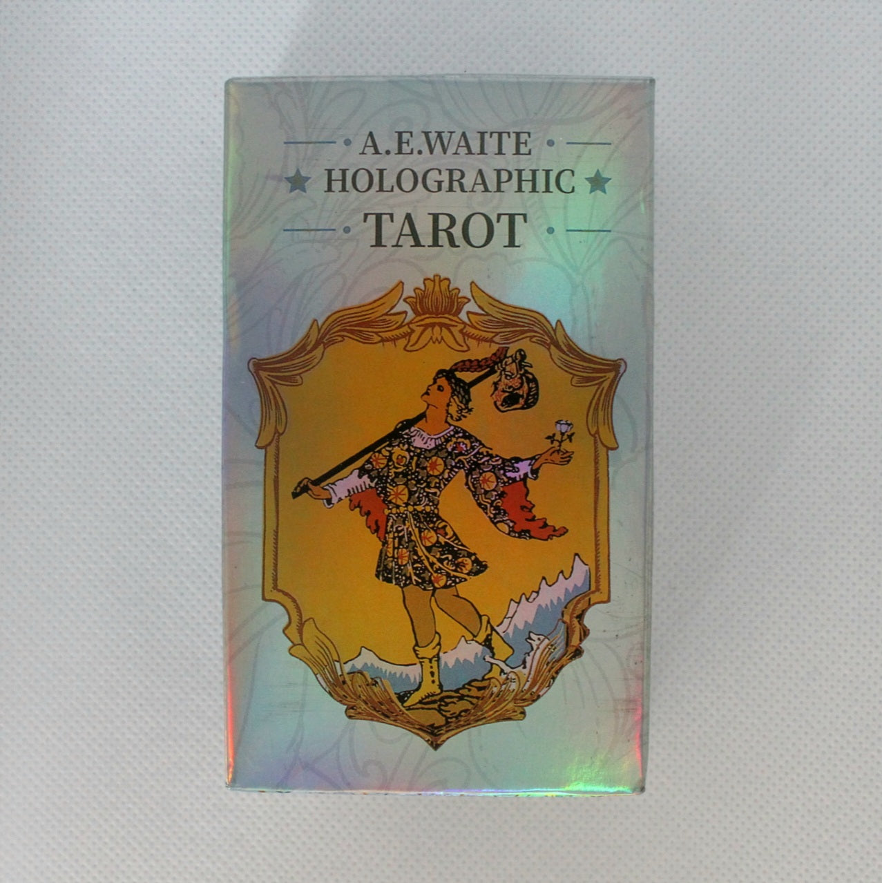 Zdjęcie opakowania talii tarota "A.E. Waite Holographic Tarot" z postacią Głupca na holograficznym tle.