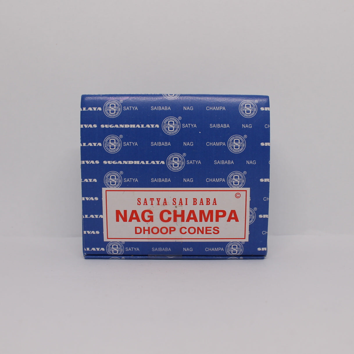 Przednia strona niebieskiego pudełka kadzideł stożkowych Satya Sai Baba Nag Champa. Na środku biała etykieta z czerwoną nazwą produktu.