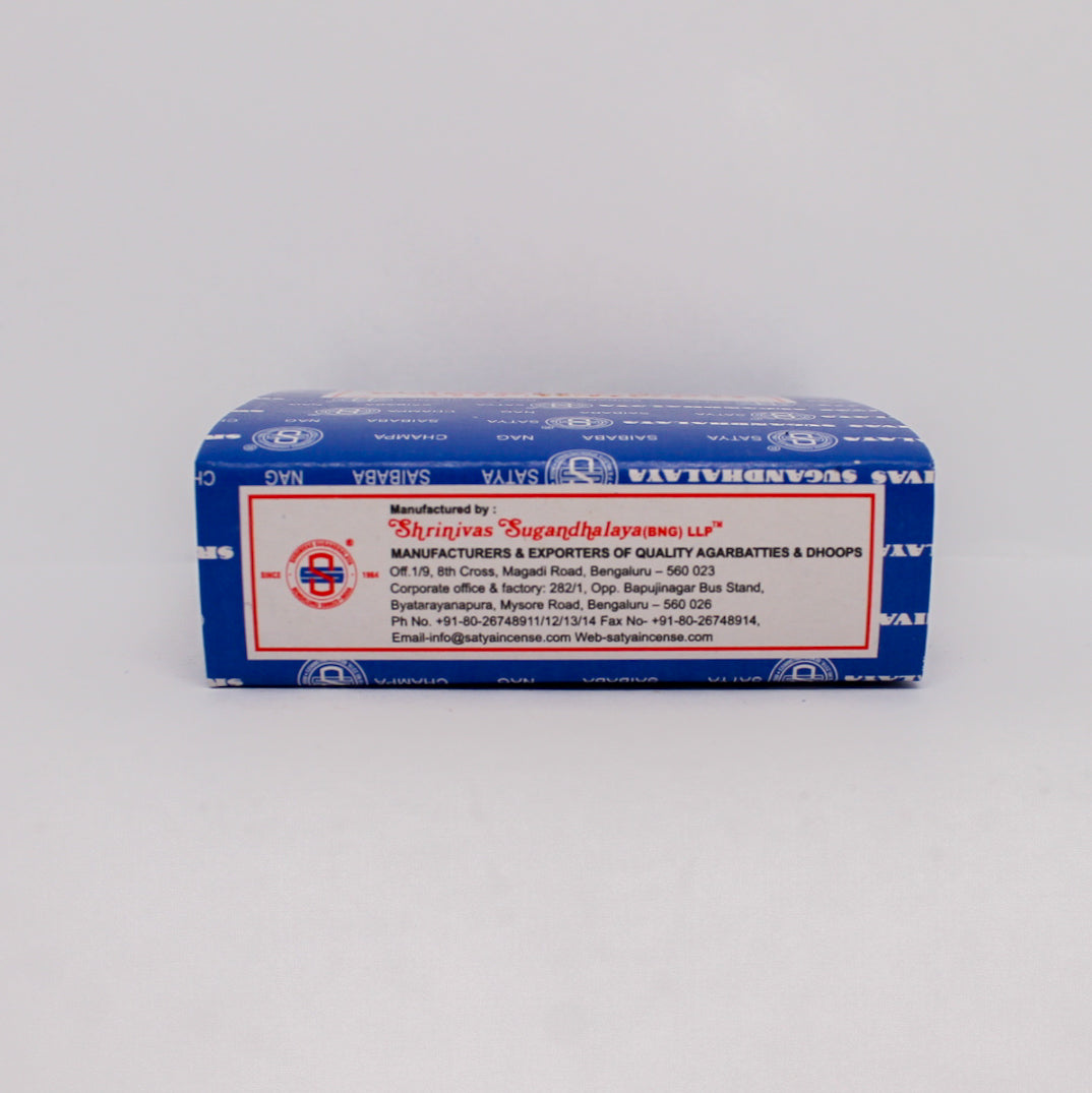 Drugi bok niebieskiego pudełka kadzideł Satya Nag Champa. Widoczna jest etykieta z danymi producenta Shrinivas Sugandhalaya LLP, adresem firmy oraz informacjami kontaktowymi.